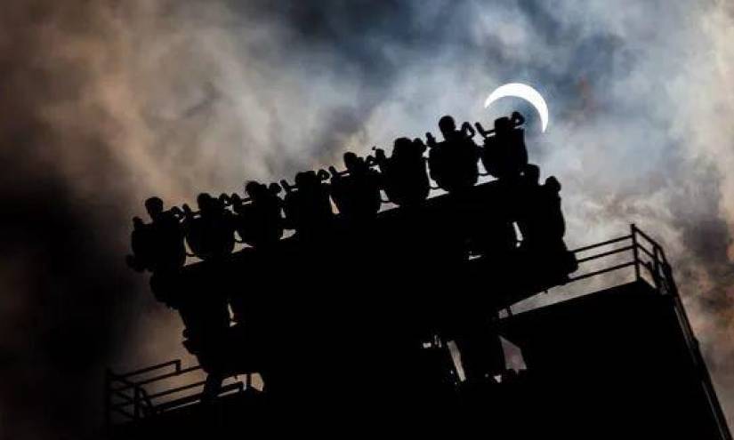 Imagen de un eclipse solar parcial en un parque de atracciones.