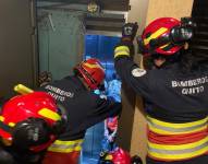 Personal del Cuerpo de Bomberos de Quito rescata a los chicos atrapados en el ascensor.