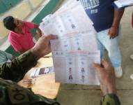 Imagen de tres papeletas marcadas a favor de un candidato, por un miembro de mesa electoral, en Palma Roja, Sucumbíos, la mañana del domingo 15 de octubre.