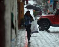 Imagen de una mujer con paraguas durante un día lluvioso en Cuenca.