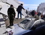 Soldados revisan un automóvil dañado en el lugar del edificio residencial objeto de un presunto ataque israelí en el barrio de Mezzah, Damasco, Siria, el 20 de enero de 2024.