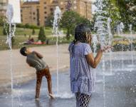Unos niños se refrescan durante la tercera ola de calor en Valencia (España)