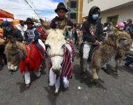 Varias personas con sus burros participan en una carrera, hoy, en Salcedo (Cotopaxi - Ecuador).