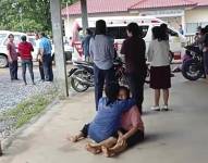En esta imagen, tomada de un video, una mujer recibe consuelo en el exterior del jardín de infantes donde se registró una balacera.