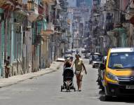 Una mujer camina con un coche para niño por una calle de la Habana (Cuba). EFE/ Ernesto Mastrascusa
