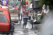 Una madre con su hijo en medio de las inundaciones en la ciudad de Malabon, Filipinas que fueron causadas por el supertifón Doksuri.