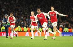Jugadores de Arsenal celebran su clasificación a los cuartos de final de la Champions League