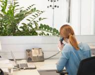 Una trabajadora contesta una llamada en su oficina.