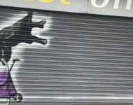 Graffiti de la mujer que quedó colgada en una persiana metálica