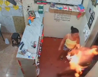 Captura de el video de la cámara de seguridad en donde se observa una mujer prendiendo en fuego a su esposo.