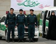 La policía de la moral frente a sus vehículos de patrullaje en Irán.