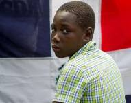 Niño con la bandera de República Dominicana de fondo