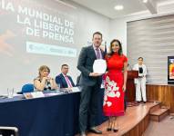 Carlos Rojas, director del programa Políticamente Correcto, recibe el reconocimiento de la presidenta del Consejo de Comunicación, Jeannine Cruz.