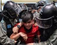 La policía arresta a un joven universitario durante las masivas protestas pro-democracia de 2019.