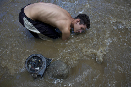Chatarreros buscan objetos de valor en un río de Venezuela