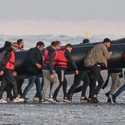 Personas con chalecos salva vidas cargando una balsa inflable