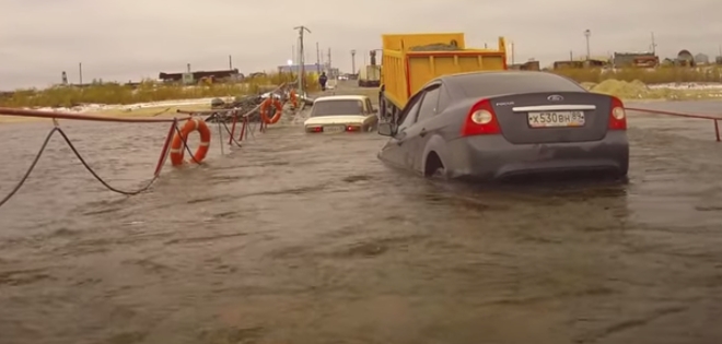 (VIDEO) Conductor intenta cruzar en auto un puente inundado pero se queda atrapado