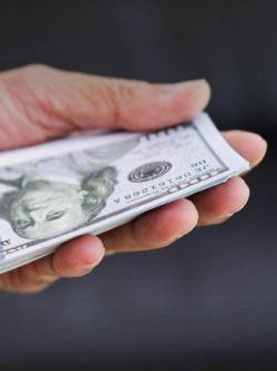 Imagen referencial de una persona contando dinero.