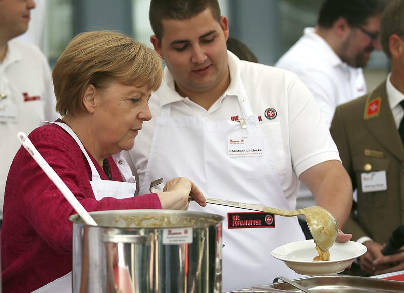 Merkel visita un centro de emergencia y prueba la sopa de papa en la cocina