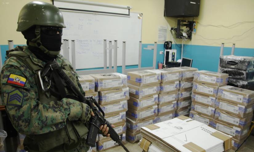 Militares resguardan los kits electorales que llegaron al colegio González Suárez, en Durán.