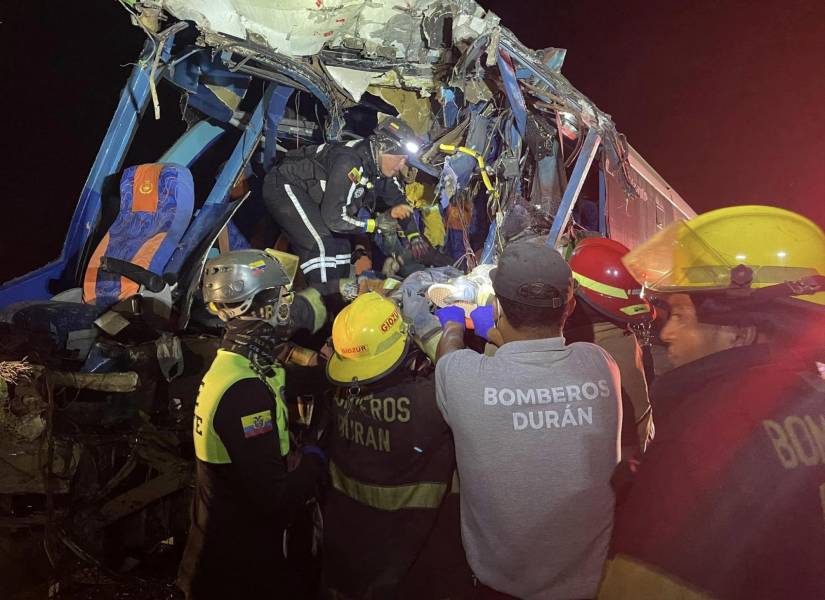 Imagen de equipos de emergencia rescatando a una persona que quedó atrapada en uno de los buses accidentados.