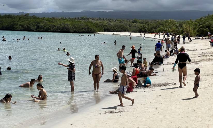 Imagen de varios turistas en la playa Tortuga Bay de la isla Santa de Galápagos, en julio del 2023.