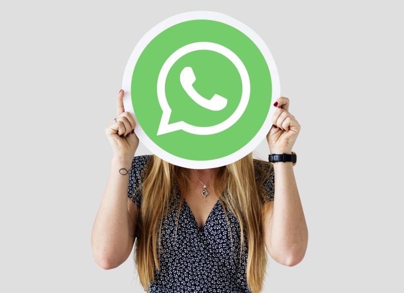 Mujer sosteniendo el ícono de WhatsApp.