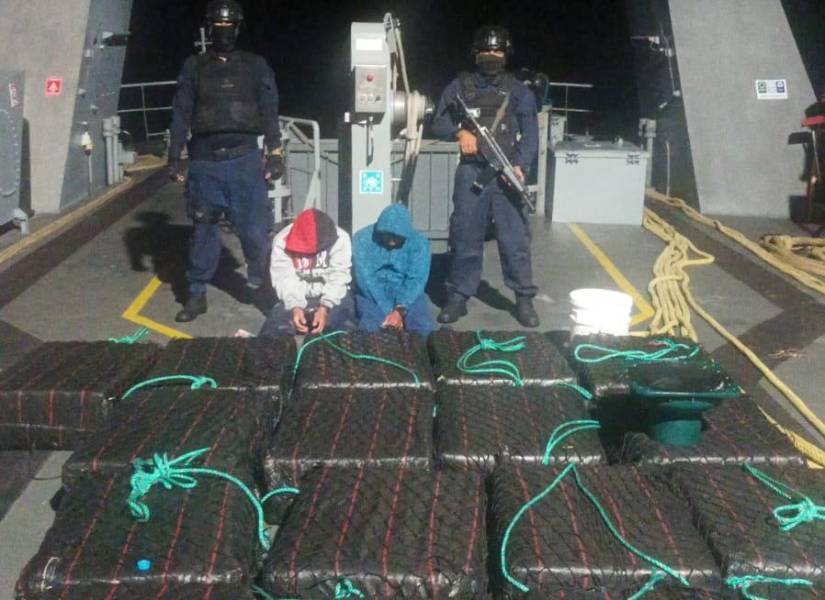 Foto de los dos detenidos junto al cargamento de droga, que estaba dentro de una lancha.