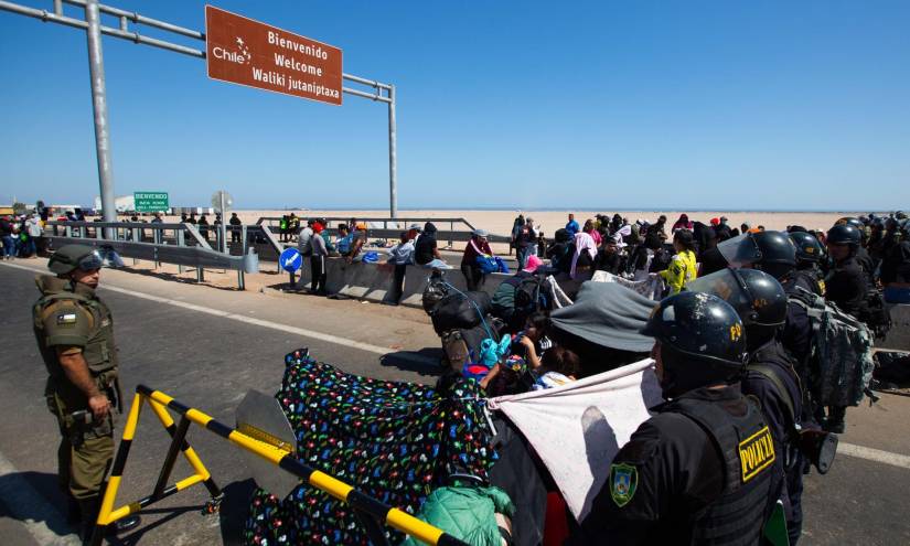 Policías peruanos y chilenos vigilan hoy a cientos de migrantes en la frontera.