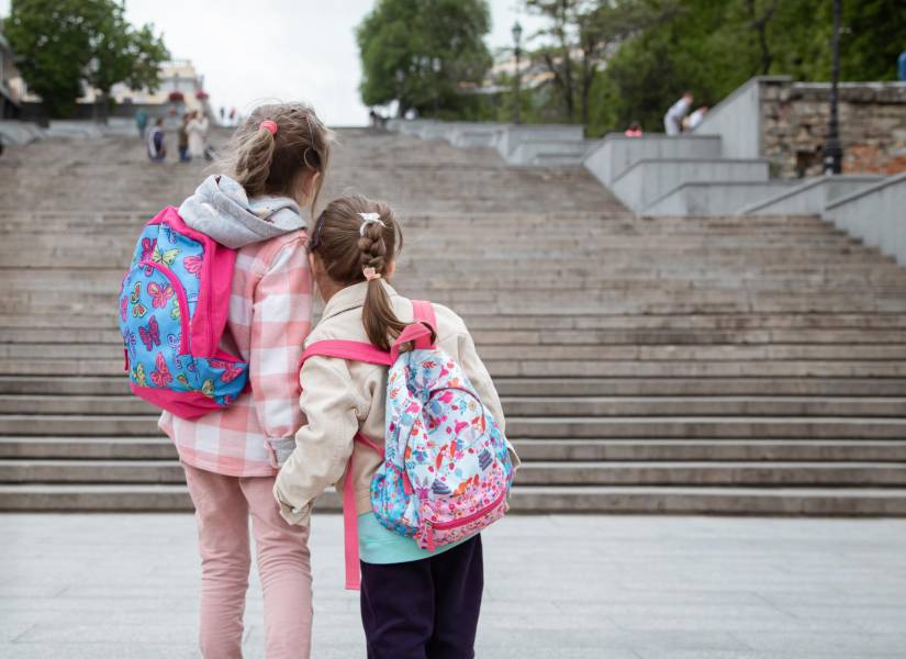 Dos niñas con sus mochilas escolares
