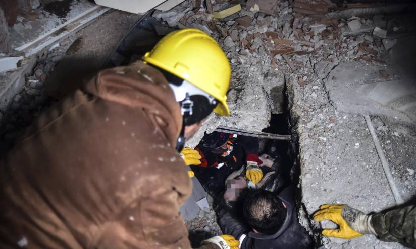 Equipos de emergencia rescatan a una mujer de entre los escombros de un edificio que se vino abajo tras un sismo, en Elbistan, Kahramanmaras, en el sur de Turquía.