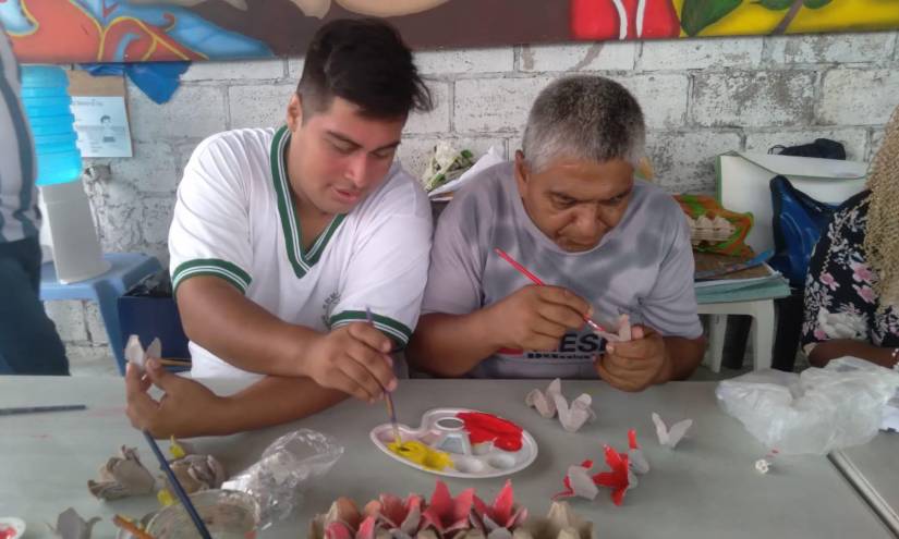 Dos hombres pintan manualidades en uno de los talleres de la fundación Hiliarte.
