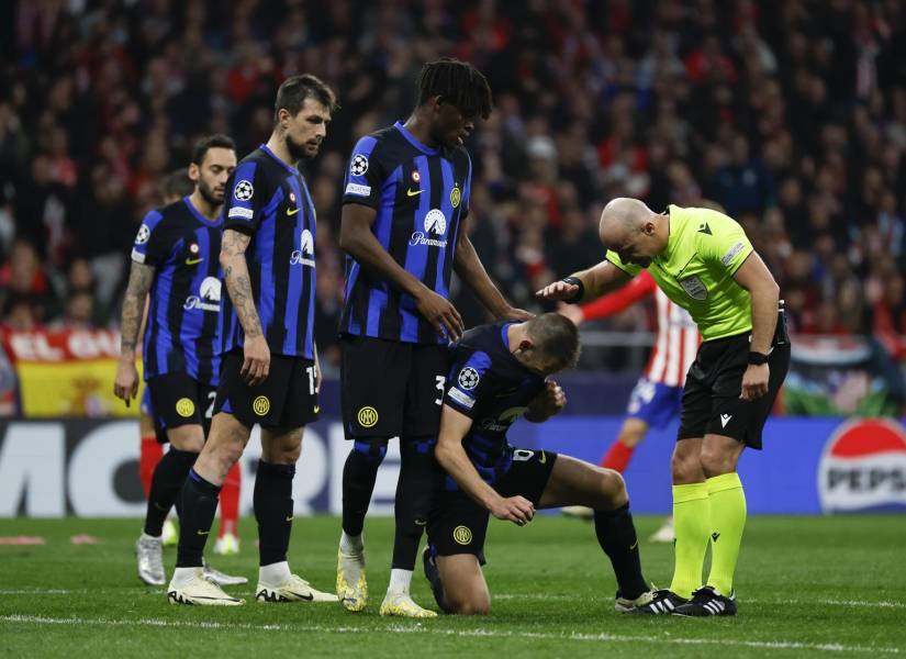 El colegiado polaco Szymon Marciniak consuela a los jugadores del Inter, tras la eliminación a manos del Atlético de Madrid.