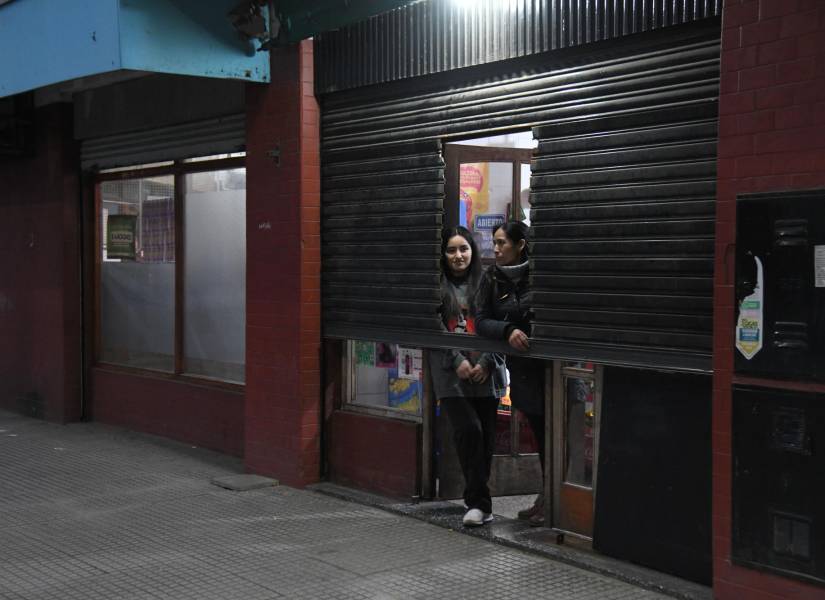 Dos mujeres fueron registradas al asomarse en la entrada de un negocio a medio abrir, debido a la ola de inseguridad en Buenos Aires, Argentina