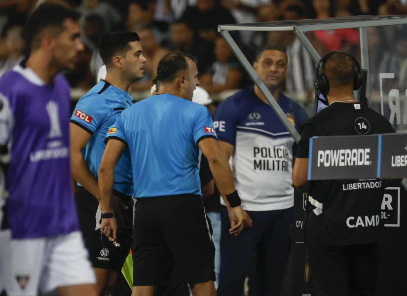 El árbitro Darío Herrera (c) revisa el VAR en el duelo entre Botafogo y LDU Quito.