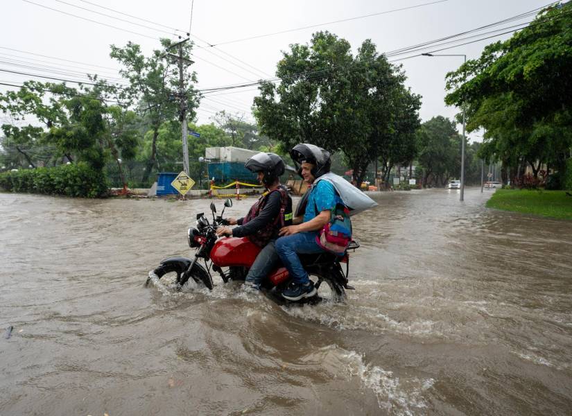 AME3441. SAMBORONDON (ECUADOR), 28/02/2024.- Motociclistas transitan por una calle inundada debido a las fuertes lluvias, este miércoles en Samborondon (Ecuador).