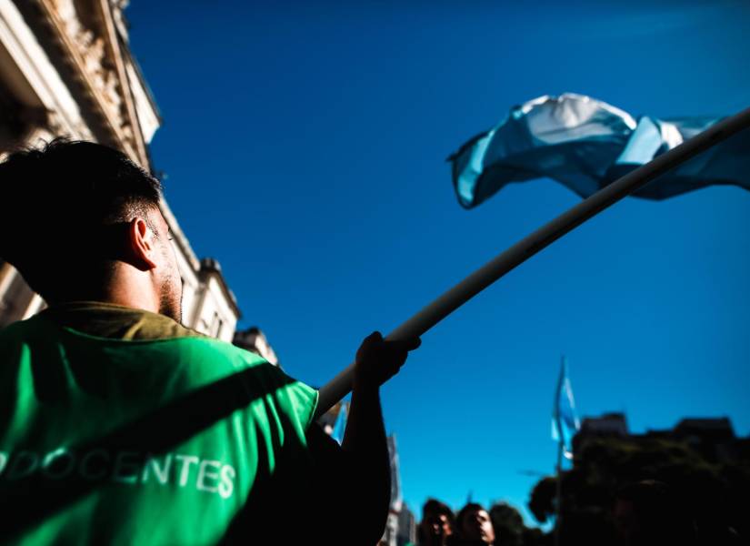 Hombre sosteniendo la bandera de Argentina durante la protesta.