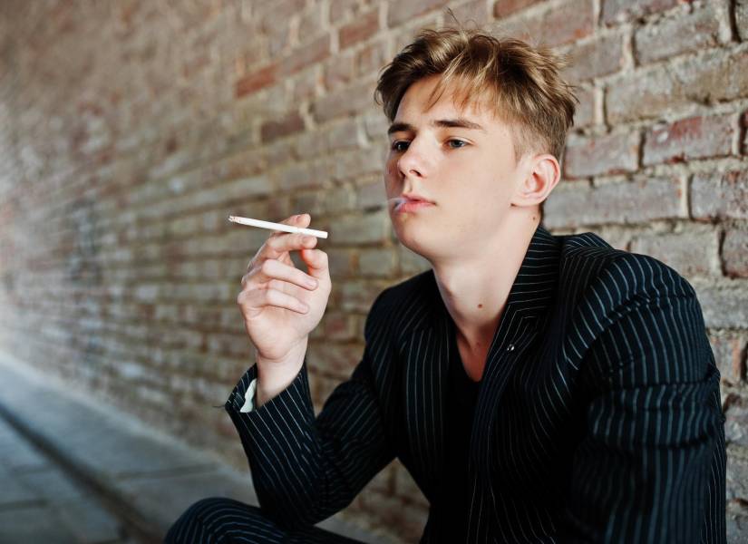 Adolescente fumando cigarrillo.