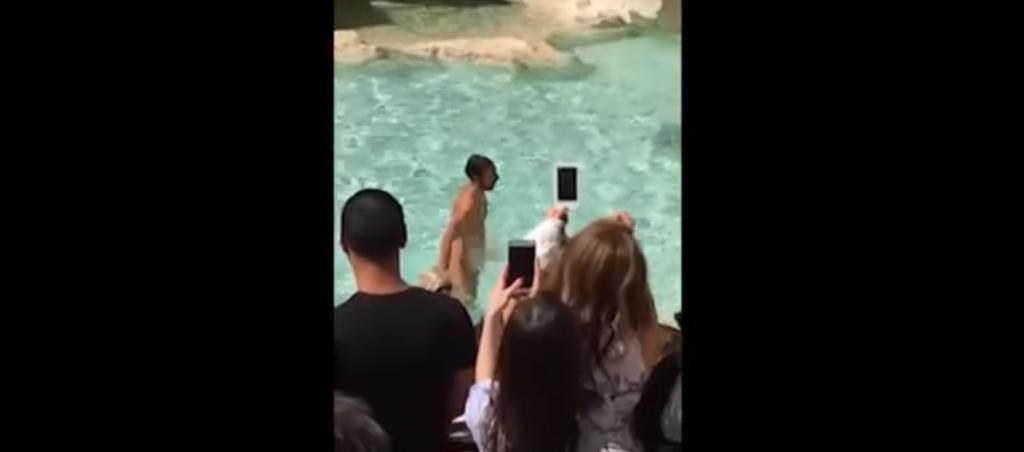 Roma: hombre nada desnudo en la Fontana de Trevi