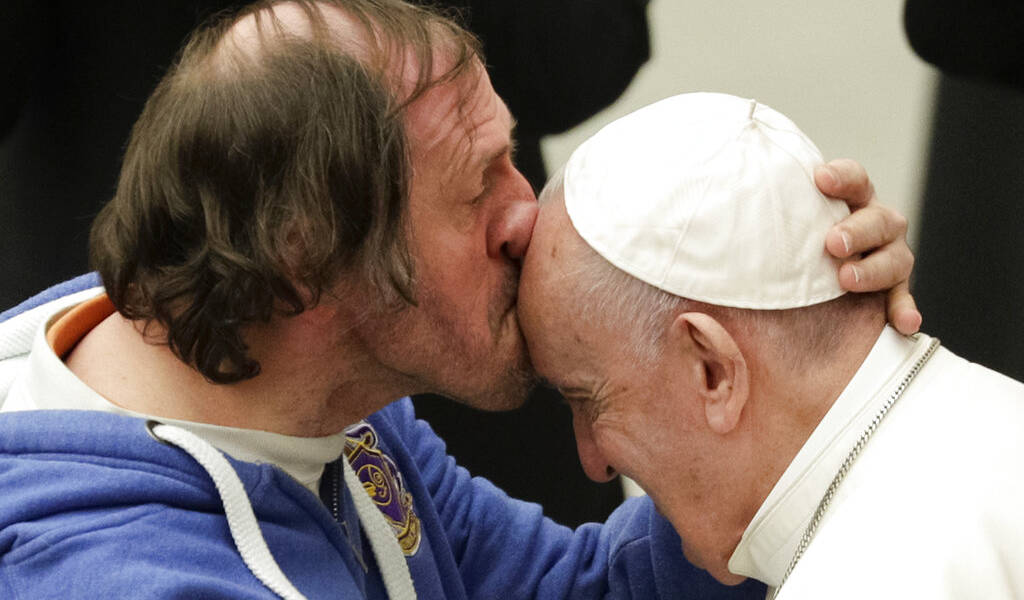 Hombre besa en la frente al papa Francisco