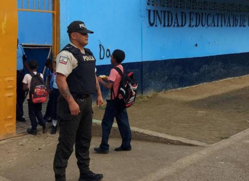 Un policía custodia el ingreso de estudiantes en una escuela de Esmeraldas.