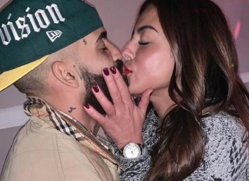 Arcángel dando un beso a su esposa Jakexsy Figueroa.