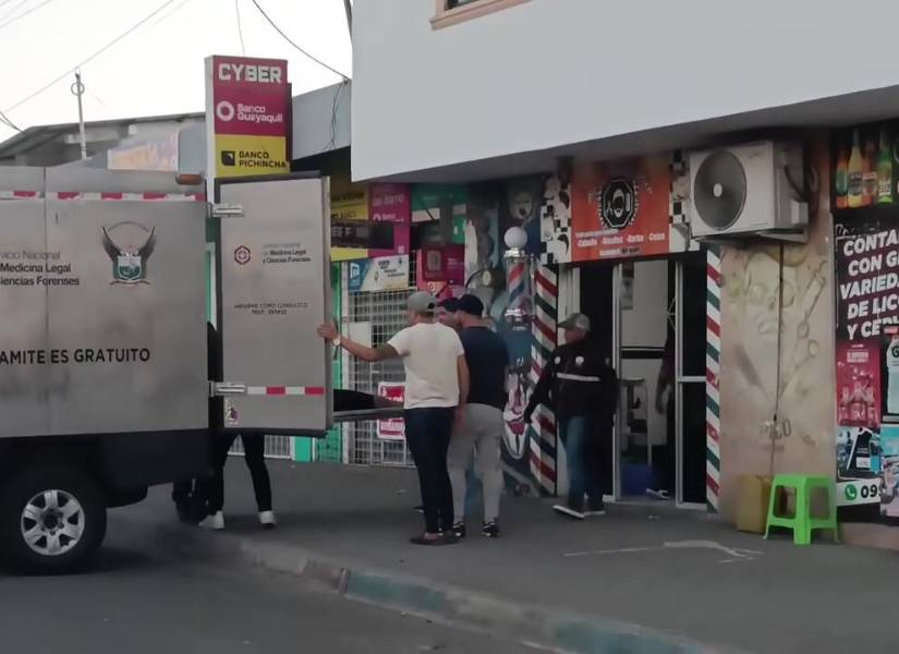Foto del momento en el que Medicina Legal levantaba el cuerpo de un joven asesinado en una barbería de Manta.