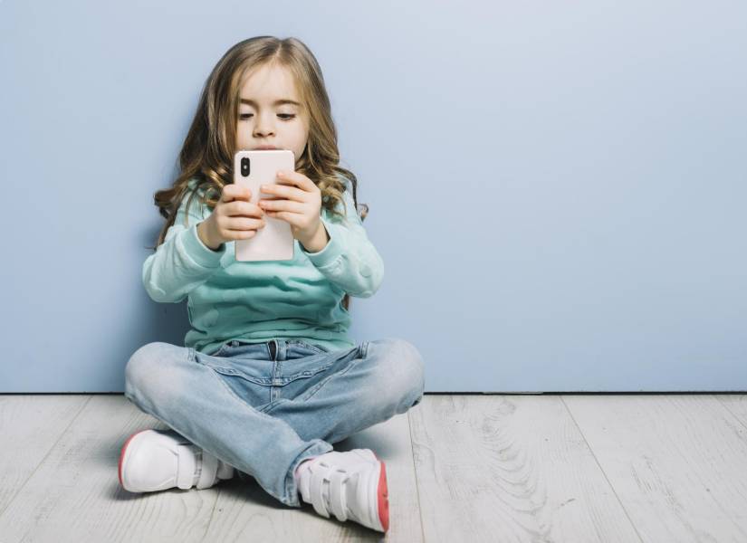 Niña usando celular.