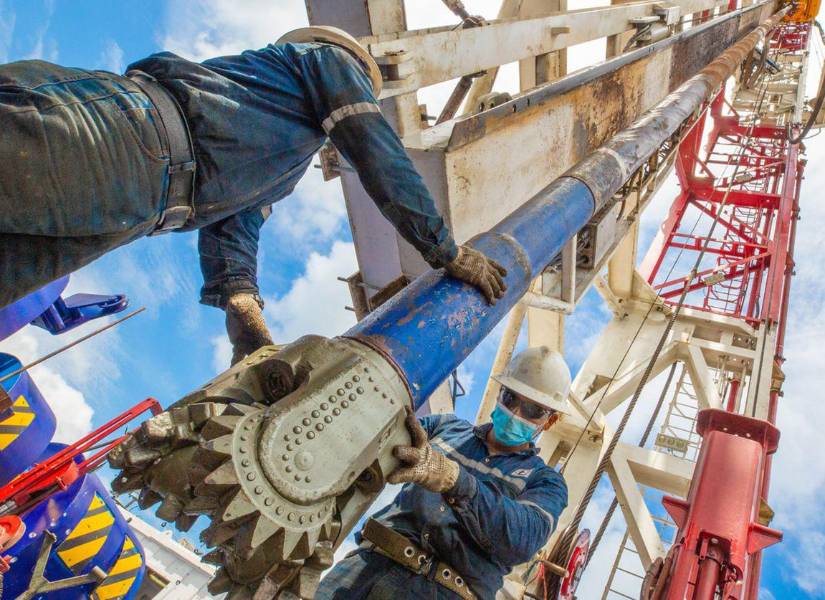 Dos trabajadores laboran en uno de los pozos del campo Sacha.