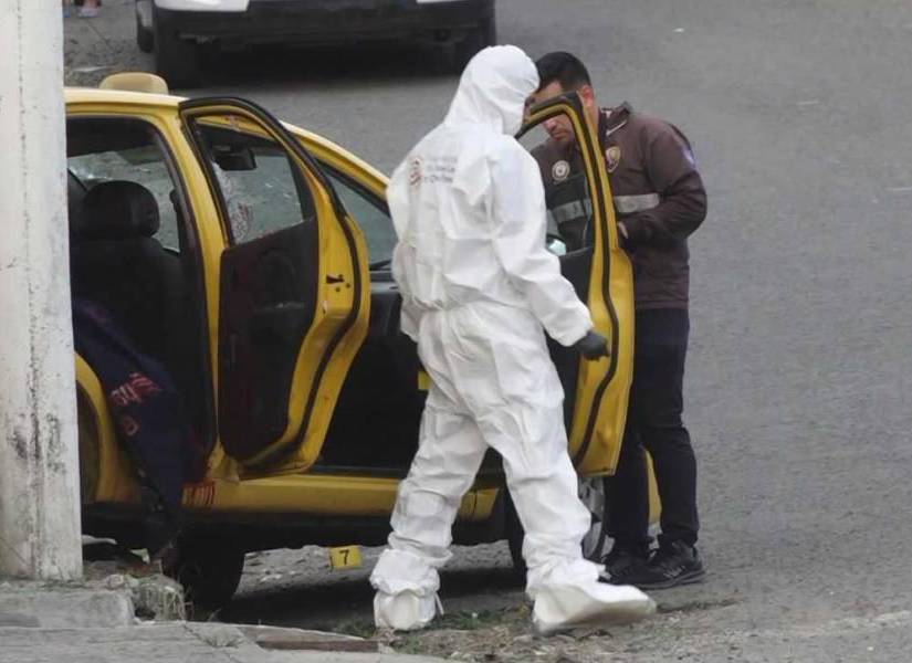 Imagen de agentes de Criminalística revisando una escena del crimen en un taxi de Portoviejo, donde fue asesinado un adolescente el pasado 2 de julio del 2023.