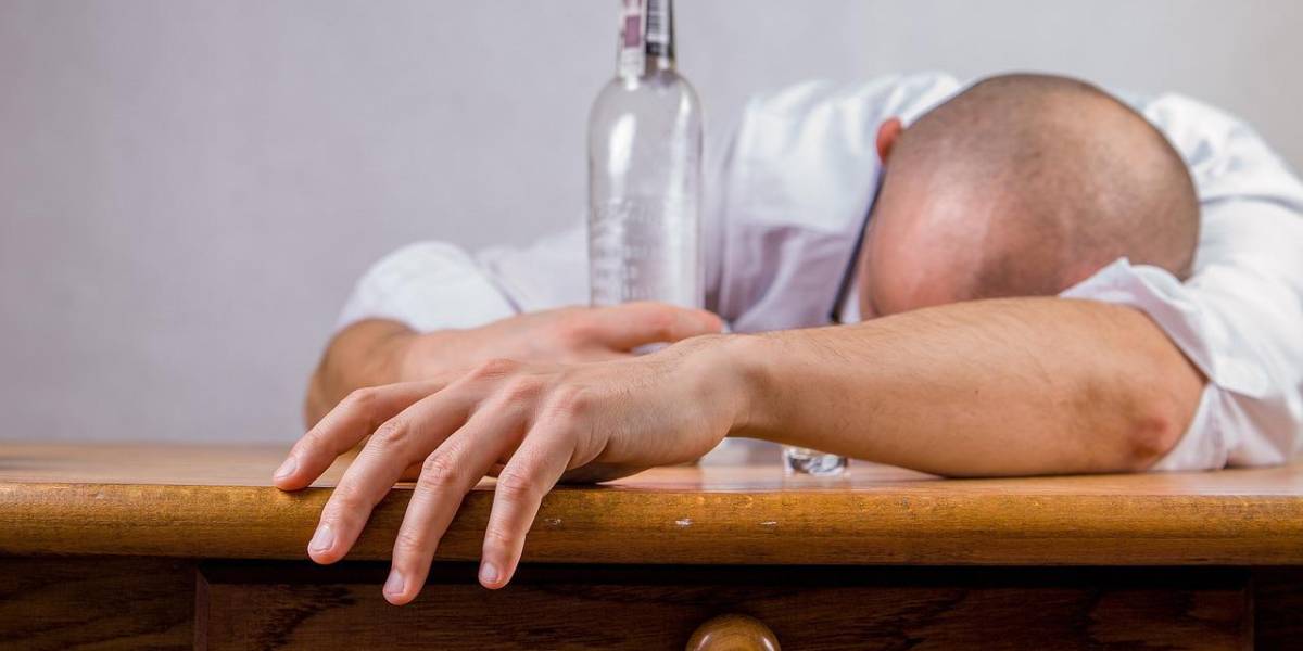 Persona acostada sobre una mesa después de haber ingerido alcohol. Foto: Pixabay / Referencial