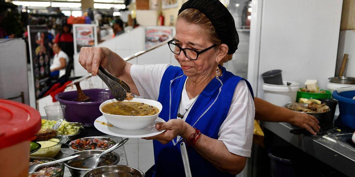Una comerciante sirviendo un plato de fanesca en un mercado municipal de Guayaquil.