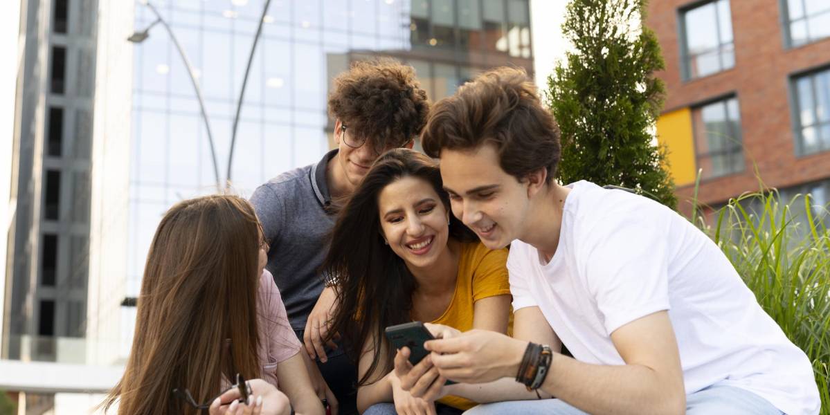Amigos al aire libre en la ciudad mirando smartphone