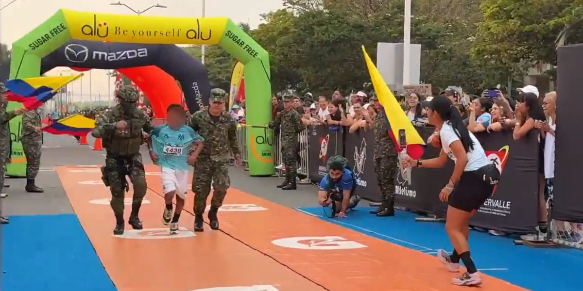 Soldados del ejército colombiano ayudan a un niño a cruzar la meta en la Maratón del Valle